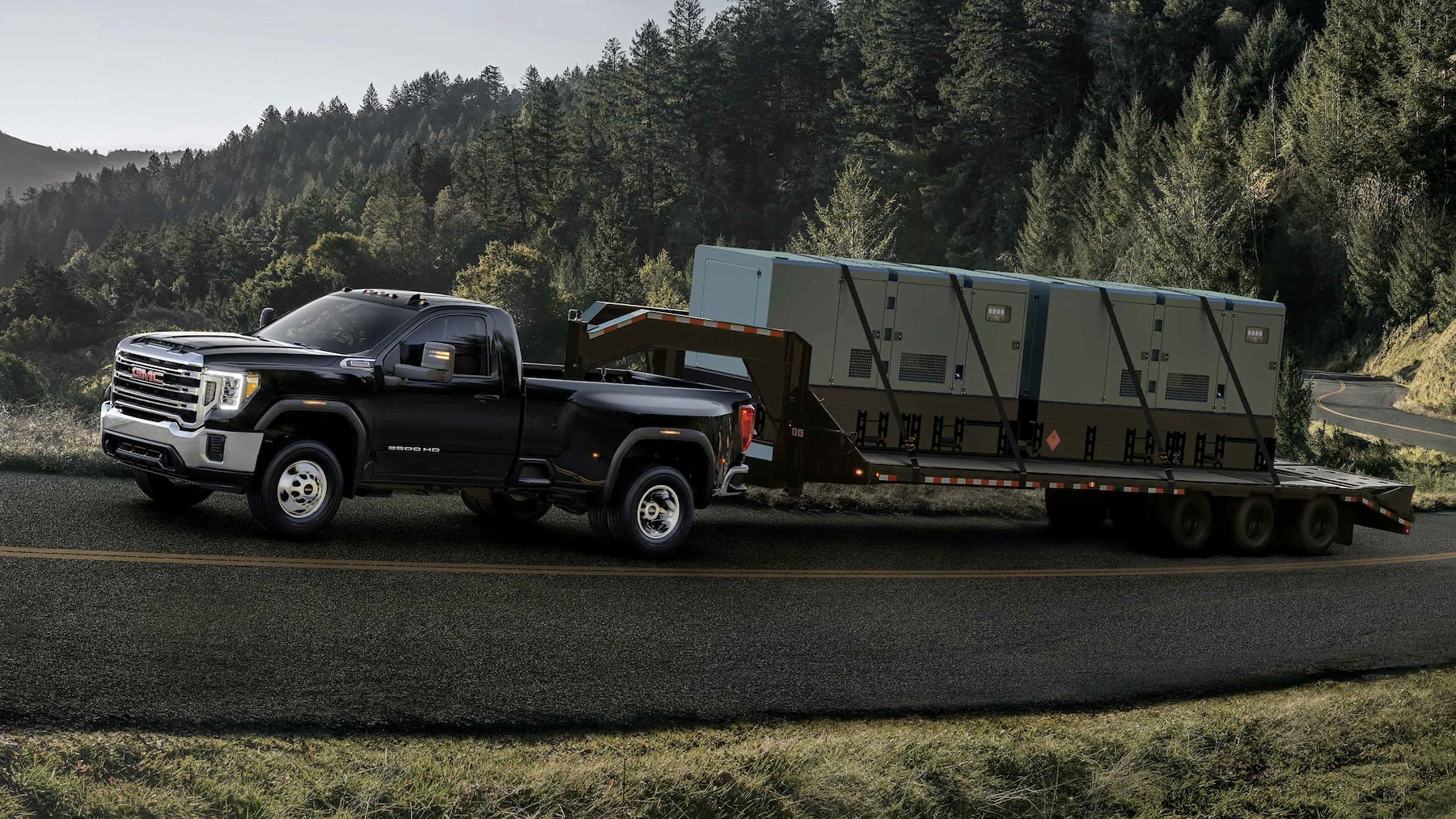 Black 2023 GMC Sierra 2500 towing a trailer.
