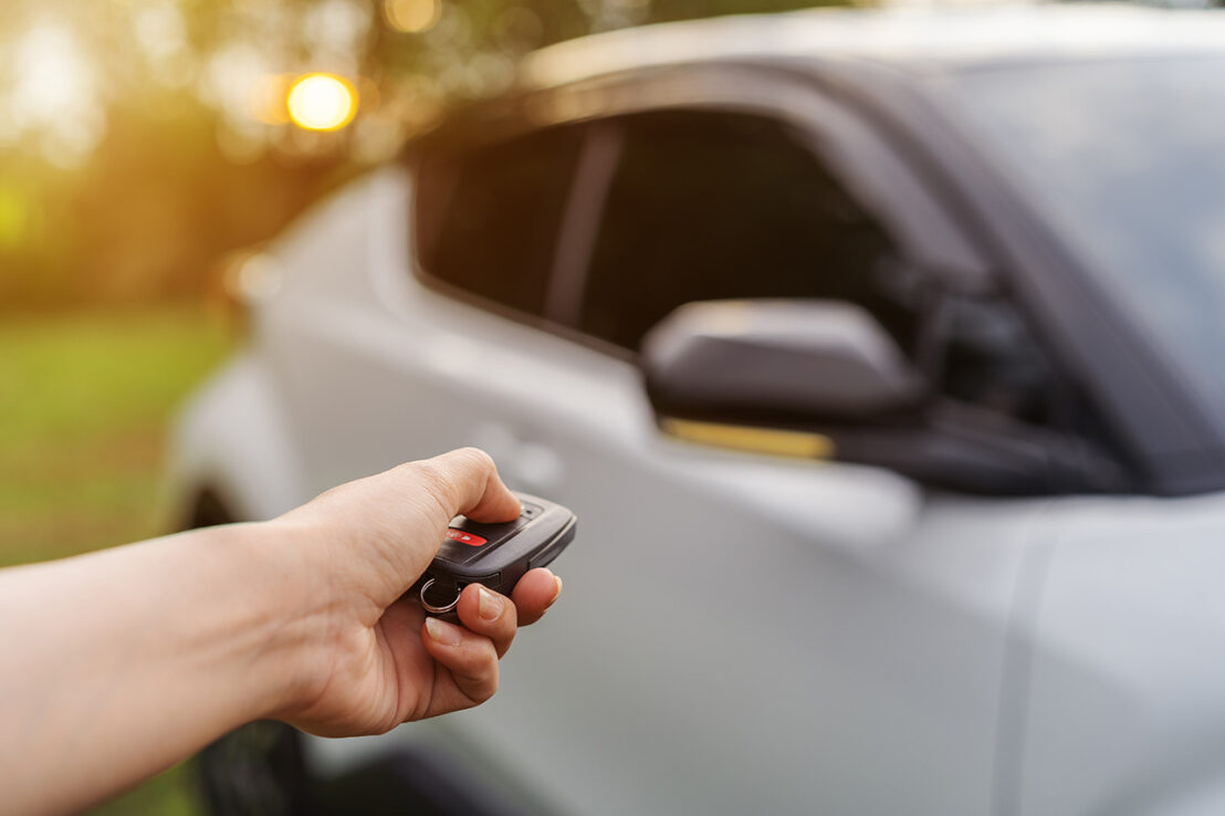 hand using remote key to unlocked car