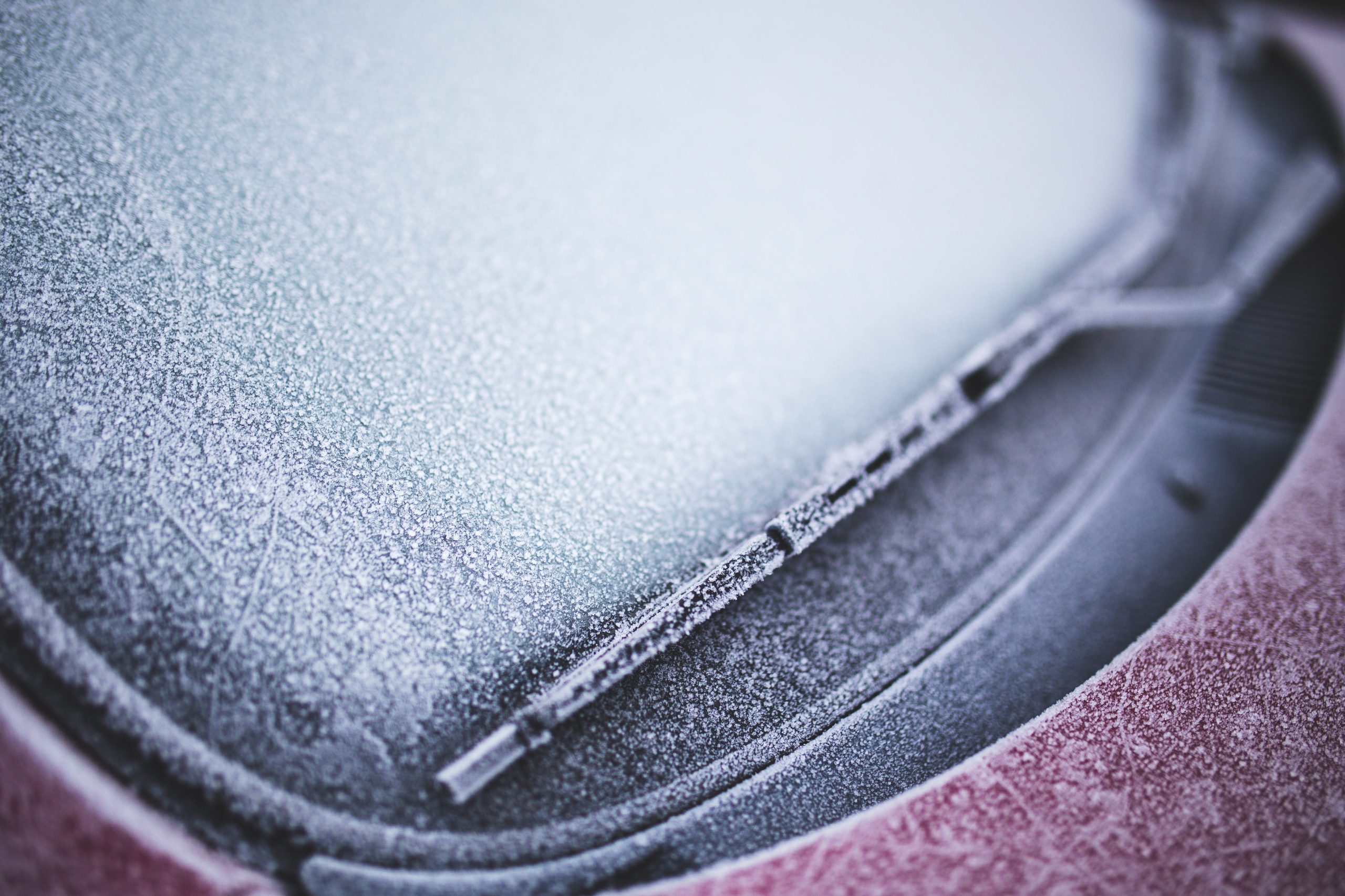 icy windshield of a red car