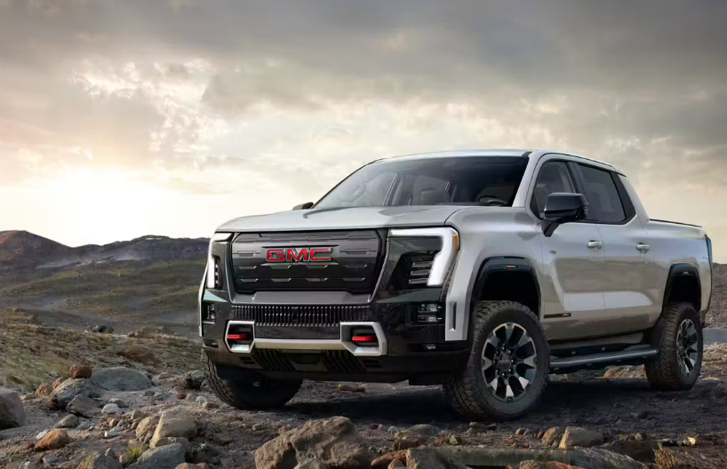 2026 GMC Sierra EV parked on top of a mountain on a cloudy day.